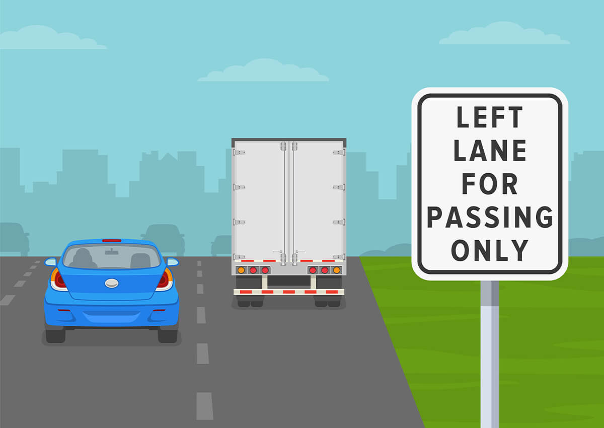 A car passing a large truck on the left with a sign that says left lane passing only